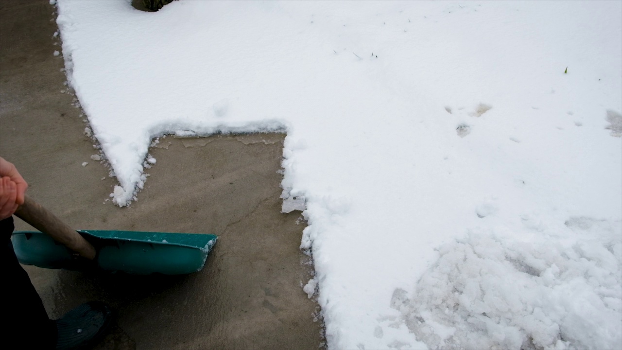 一个人用铲子清理雪。有选择性的重点。冬天视频素材