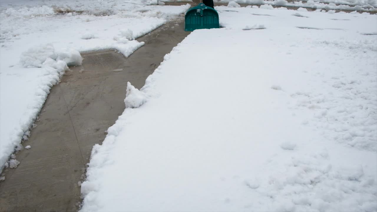 一个人用铲子清理雪。有选择性的重点。冬天视频素材