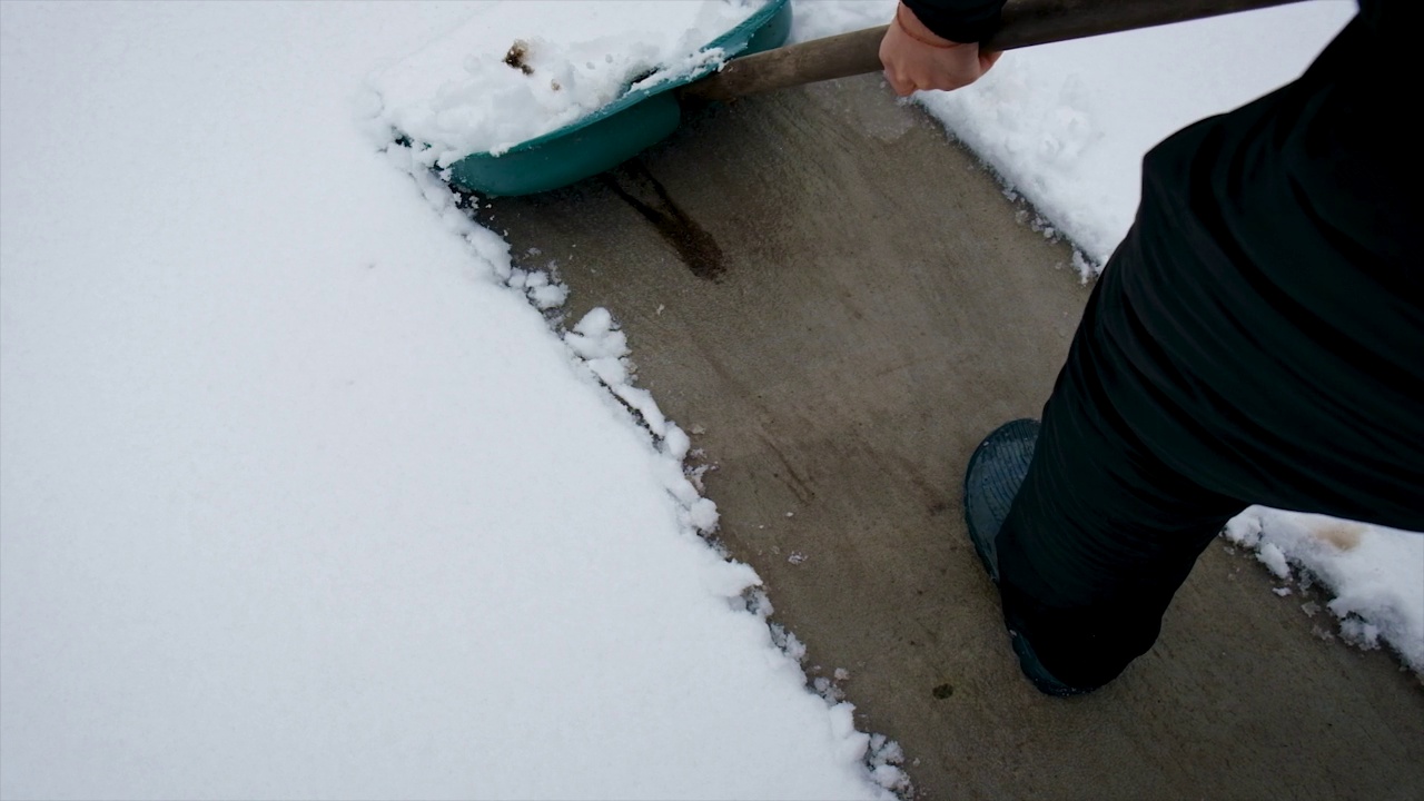 一个人用铲子清理雪。有选择性的重点。冬天视频素材