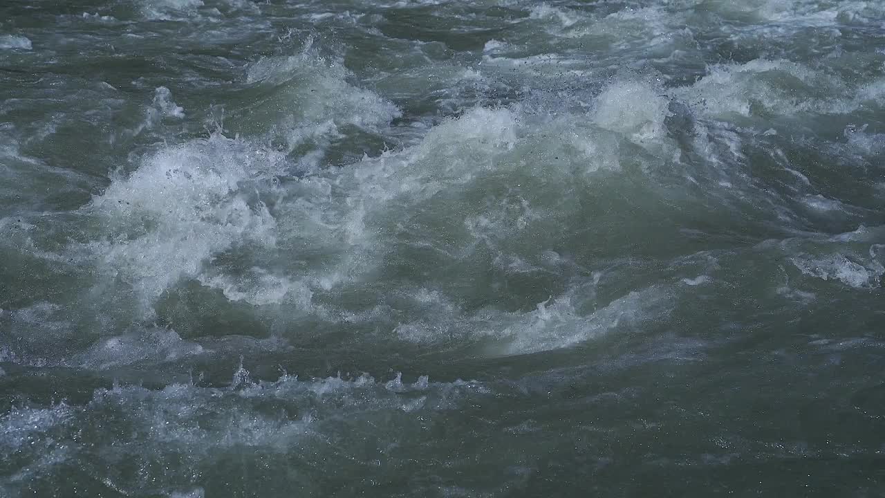 近距离的汩汩的水在鹅卵石在一条河视频素材