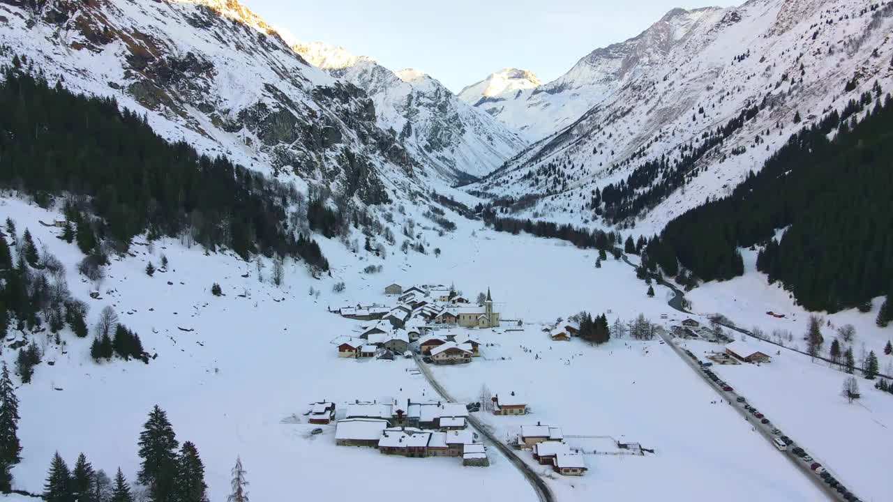 令人惊叹的瑞士小村庄鸟瞰图，位于两座覆盖着积雪的高山脚下，冬季瑞士滑雪度假小镇的全景，传统的小木屋，酒店和游客目的地的小屋。瑞士的冬季阿尔卑斯山，视频素材