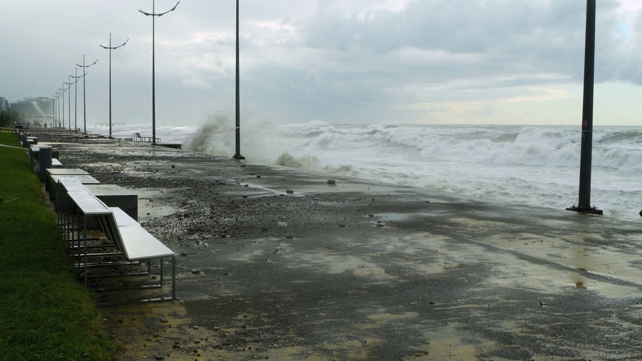 在极端的暴风雨天气中，海浪冲击着被摧毁的道路和海岸线视频素材