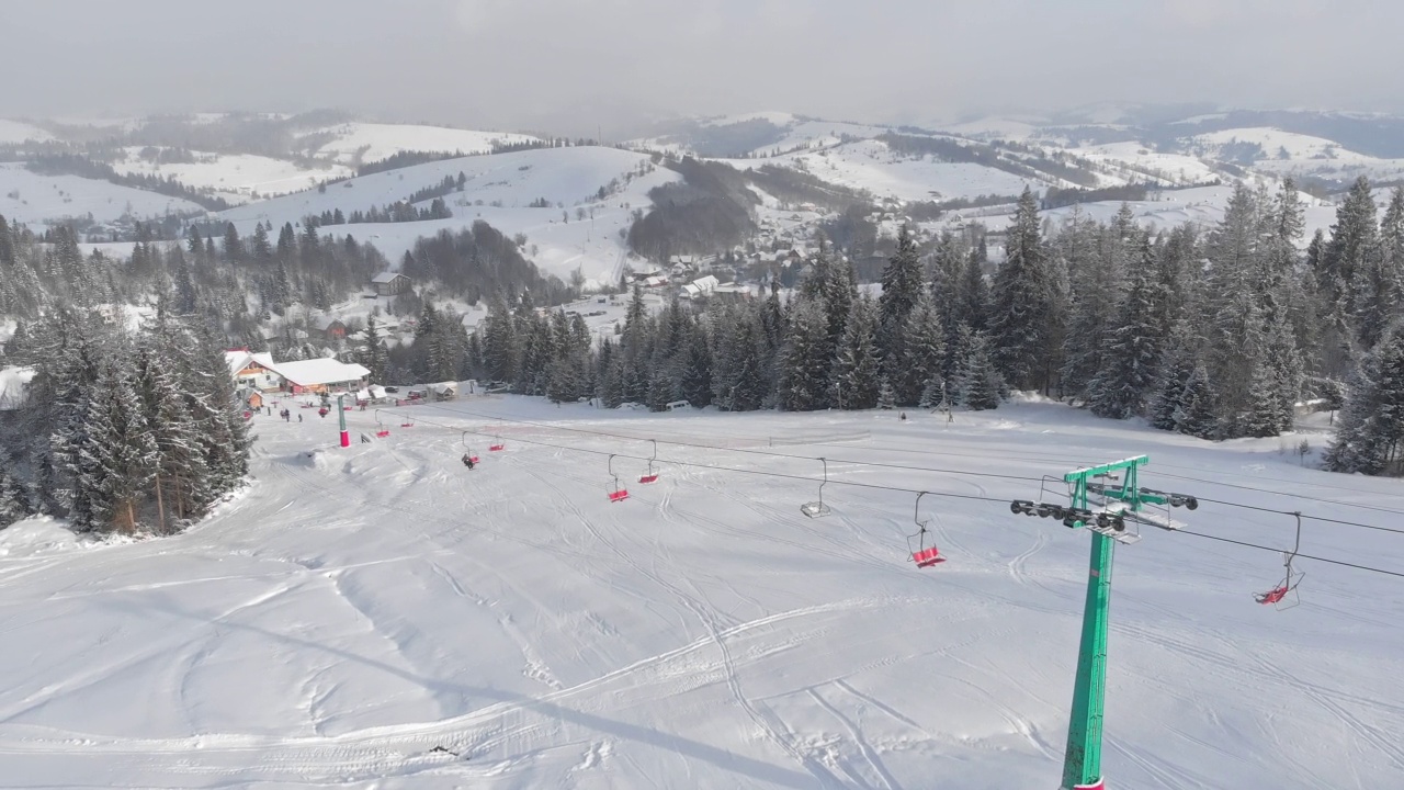 在日落时，冬季山脉景观与滑雪坡道和滑雪缆车视频素材