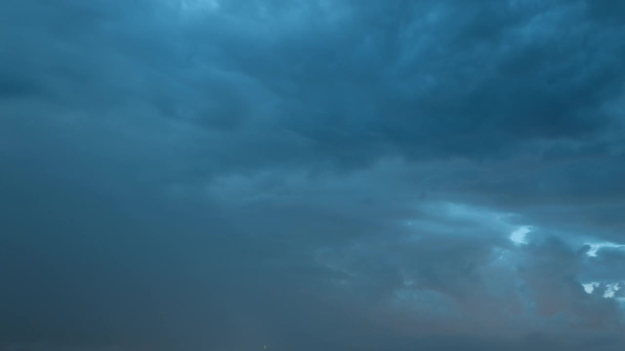 4K时间延时夜景深蓝色多云多雨的天空。雨夜中闪电雷鸣的戏剧性天空。恶劣天气延时视频素材