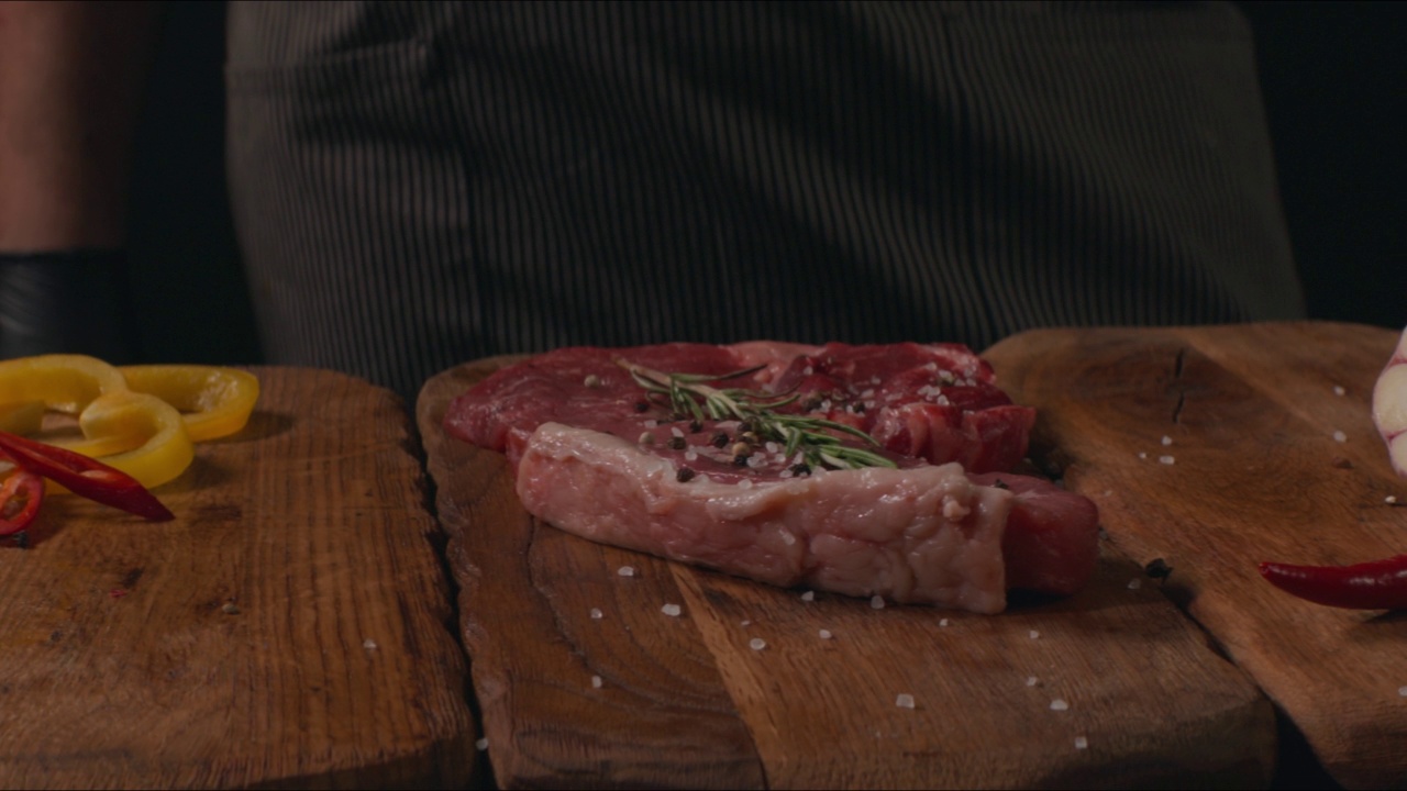 厨师正在准备做牛排。有机生牛肉配迷迭香视频素材