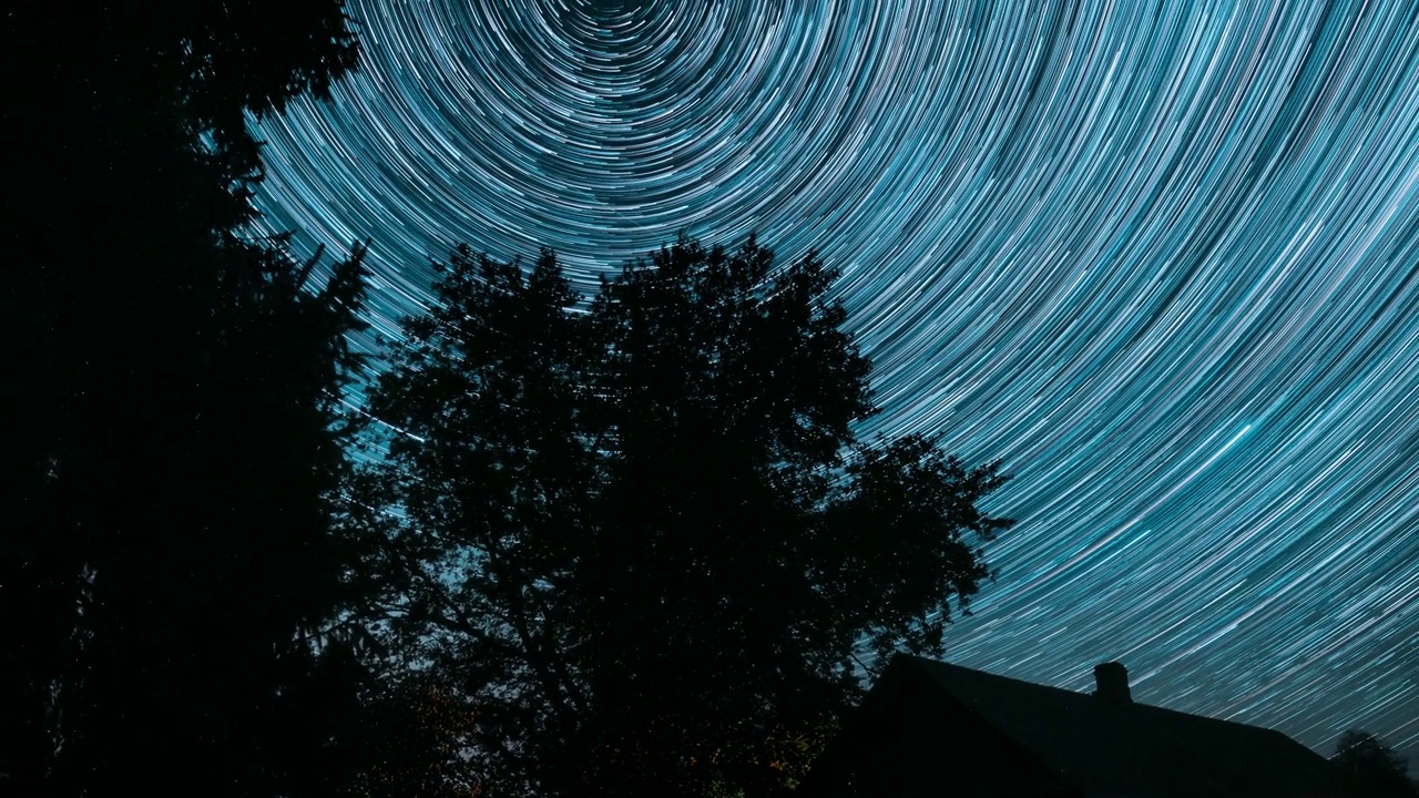 戏剧性的黄昏天空旋转轨迹的星星在夜空背景。4k超缩。星星和流星轨道轨道旋转以上的乡村老庄园乡村景观。时间流逝，时间流逝，时间流逝视频素材