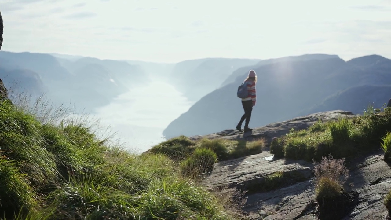 女子在Lysefjorden的背景下徒步旅行视频素材