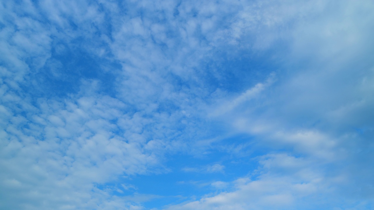 蓝色的天空，白色蓬松蓬松的云在高空翻滚。天空有云的天气。时间流逝。视频素材