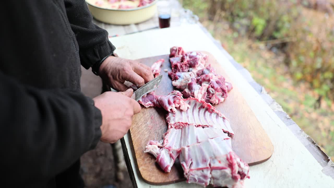 男性手在砧板上切烤肉视频素材