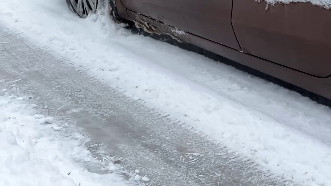 汽车行驶在森林地区积雪覆盖的光滑道路上。车轮打滑的POV特写。冬季驾驶危险概念。水平全高清视频1920x1080 30帧视频素材