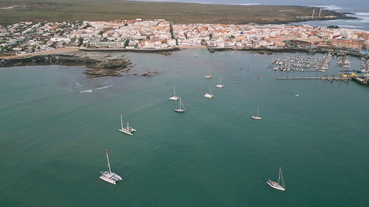 在富埃特文图拉(Fuerteventura)，高空鸟瞰Corralejo镇、海滩和港口清晨的月落视频素材