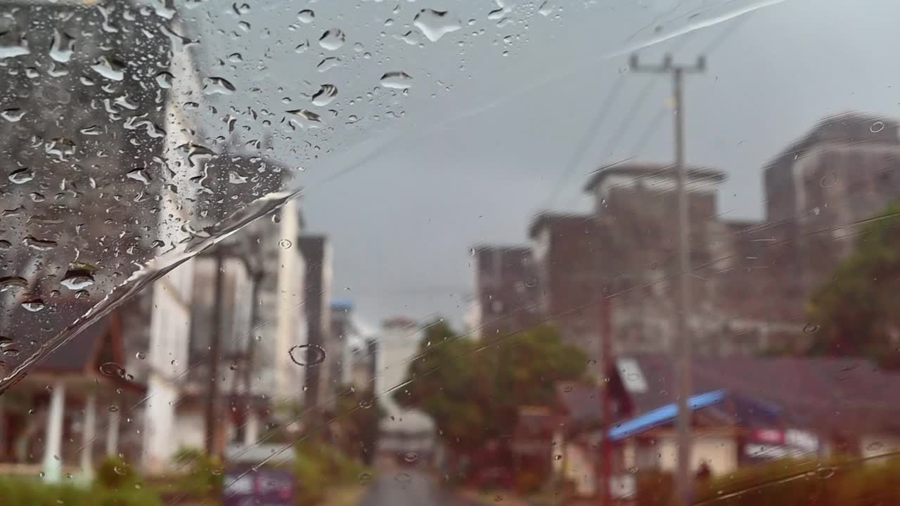 雨水落在挡风玻璃上时移动的汽车雨刷。视频素材