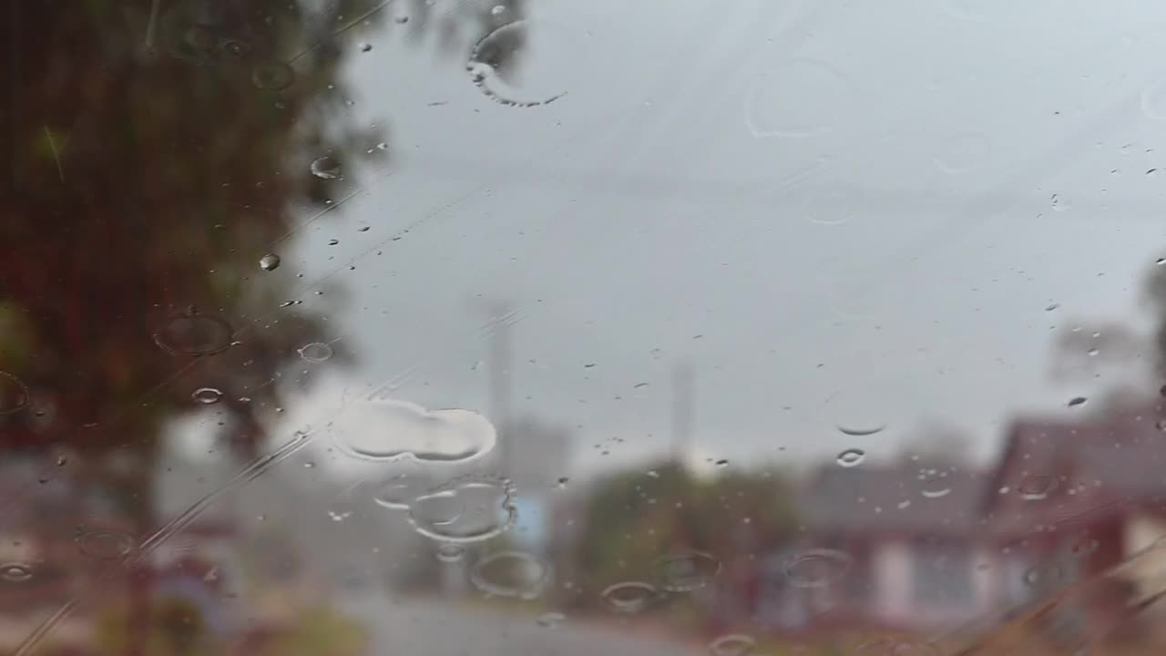 雨水落在挡风玻璃上时移动的汽车雨刷。视频素材