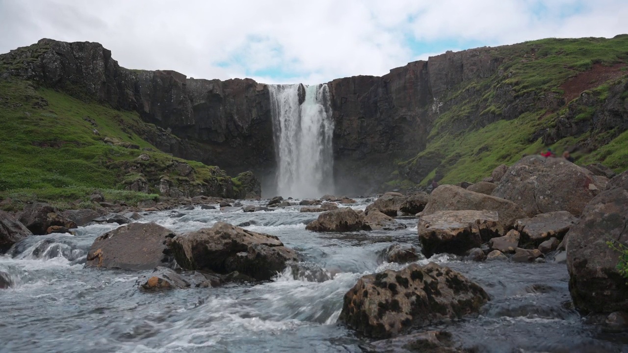 在冰岛Seydisfjordur，游客在夏季旅行时，观看流经岩石的Gufufoss瀑布视频素材