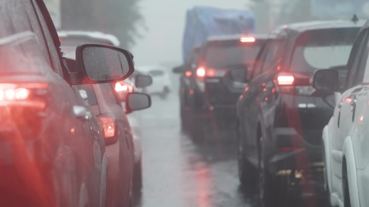 在被雨水堵塞的道路上，模糊的汽车队列视频素材