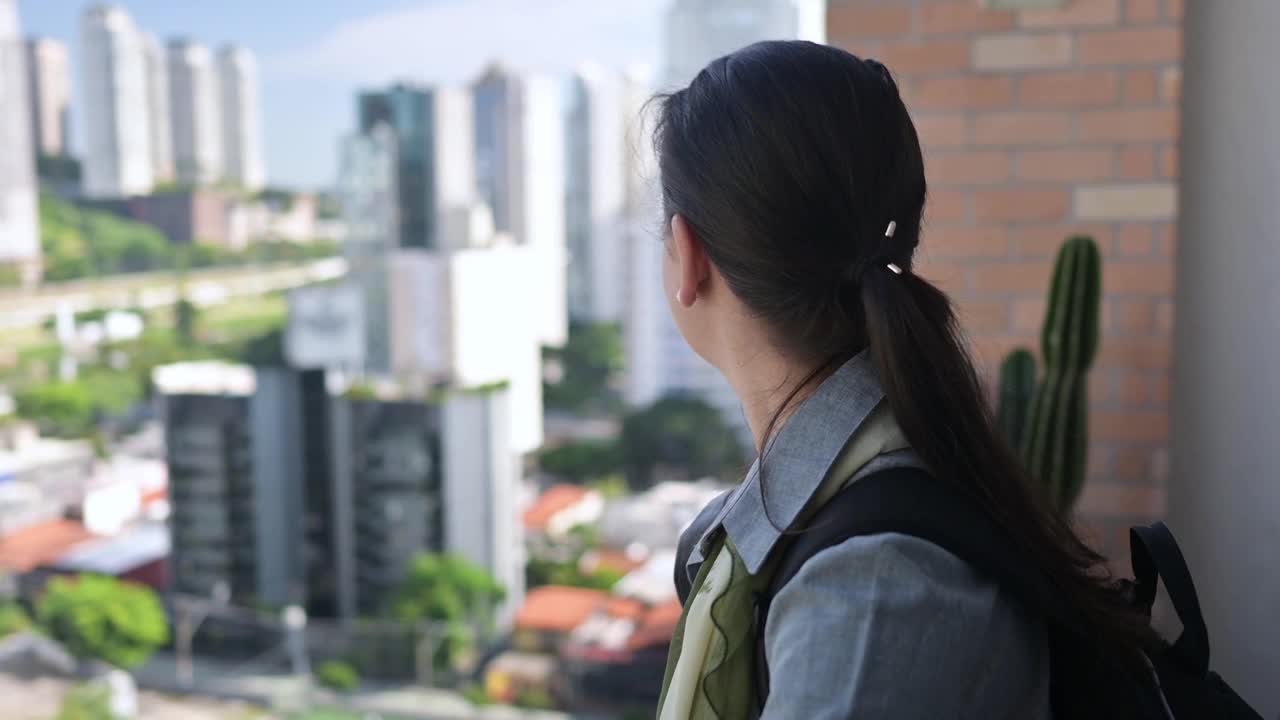 女人从酒店的窗户看城市风景视频素材