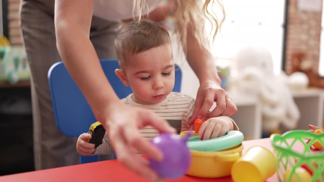 在幼儿园，老师和学前班的学生坐在桌子上学习吃饭视频素材