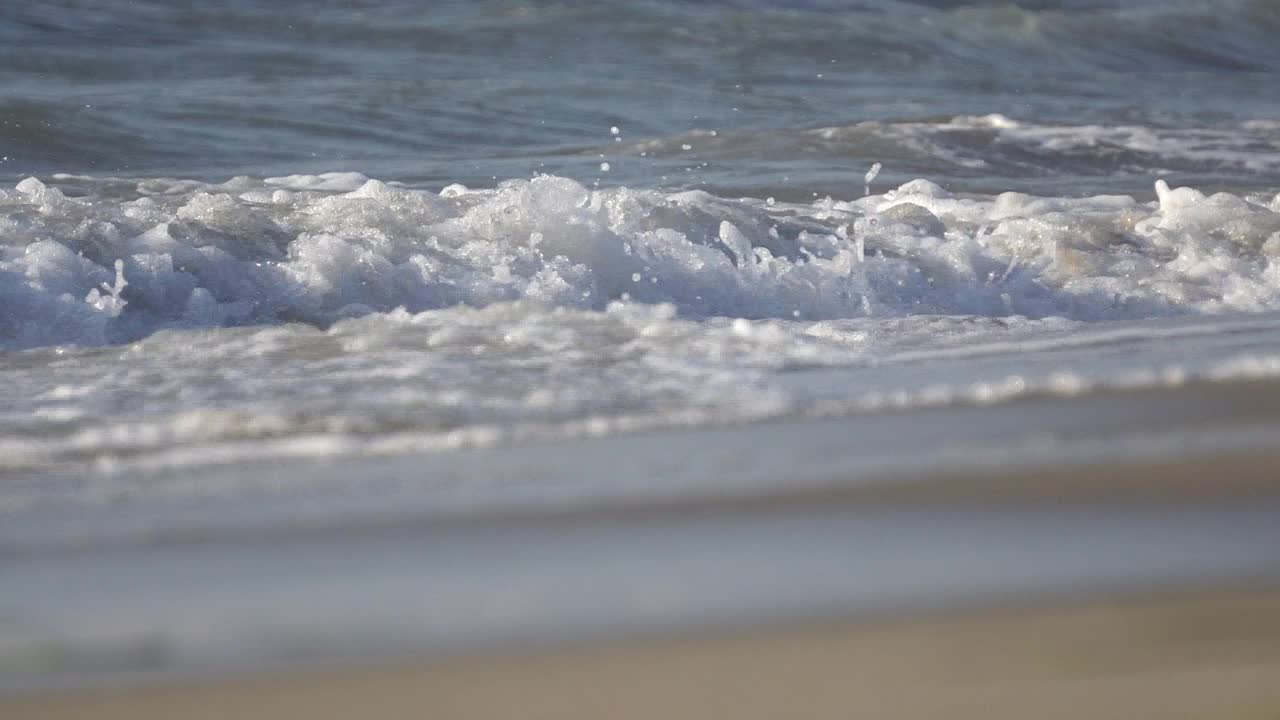 特写海浪溅湿海滩沙子干燥，电影dof视频素材