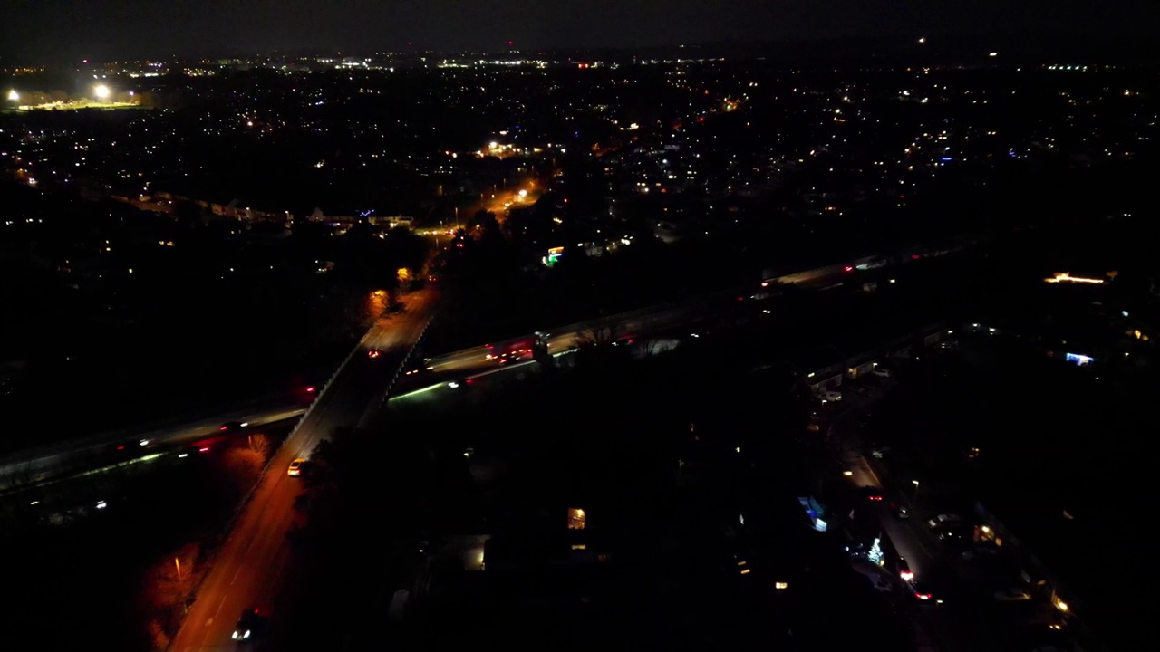 夜间城市道路上行驶的汽车的鸟瞰图，它们的前灯照亮了道路视频素材