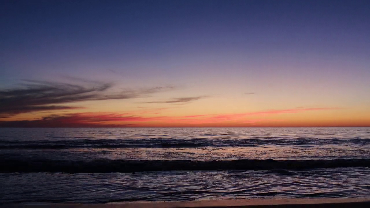 沙滩上黄色的夕阳。海景为背景。色彩斑斓的天空。美丽的水倒影。阳光视频素材