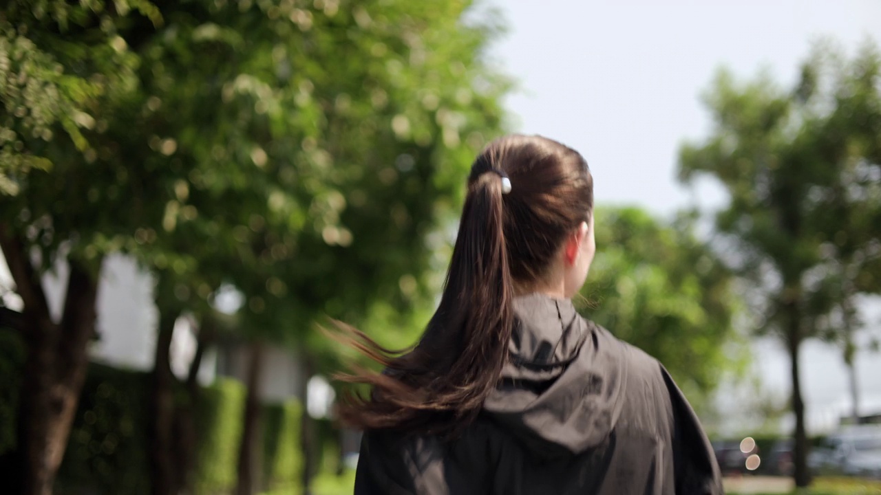 漂亮迷人的女人穿着运动服在公园里跑步。健康的女人慢跑在户外在村庄。在早上锻炼。健康积极的生活方式理念。视频素材