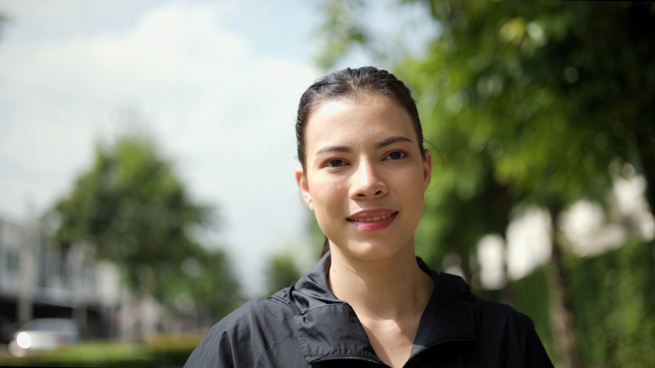 漂亮迷人的女人穿着运动服在公园里跑步。健康的女人慢跑在户外在村庄。在早上锻炼。健康积极的生活方式理念。视频素材