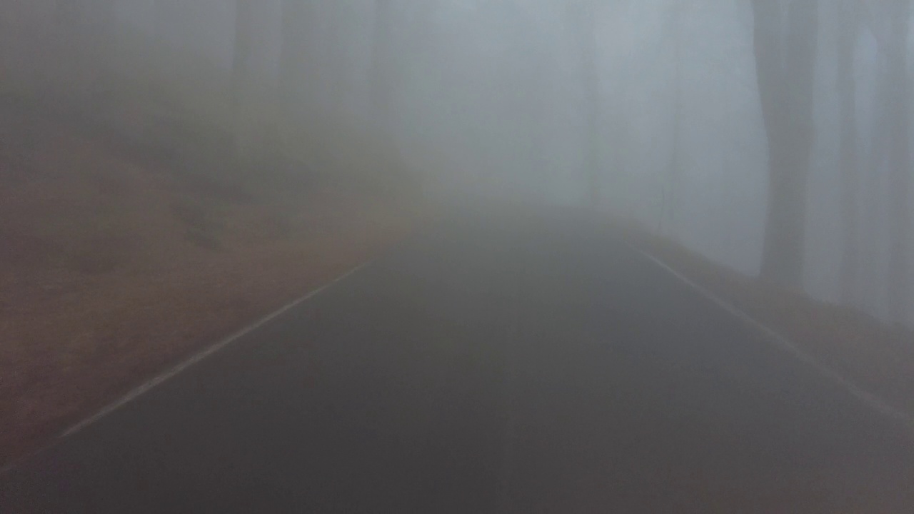 摄像车沿着一条通往蒙塔山顶的道路在雾中追踪视频素材