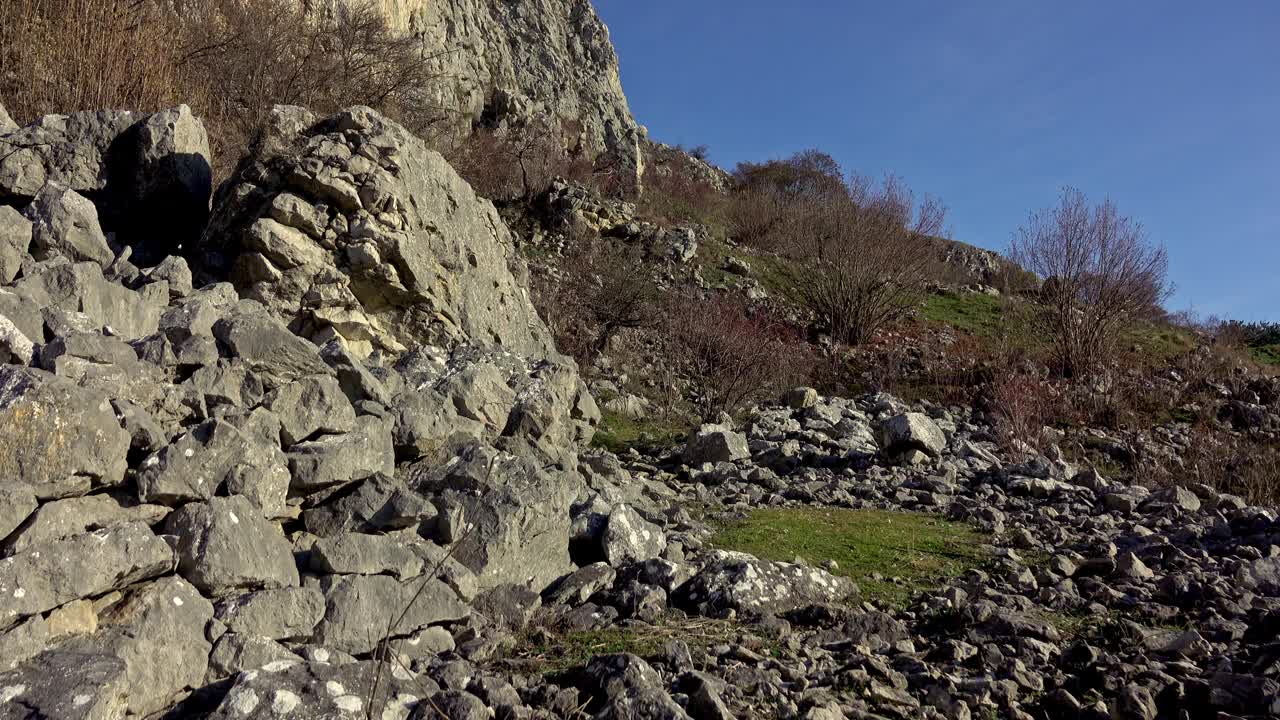 徒步旅行者沿着陡峭的碎石地形到达山顶视频素材