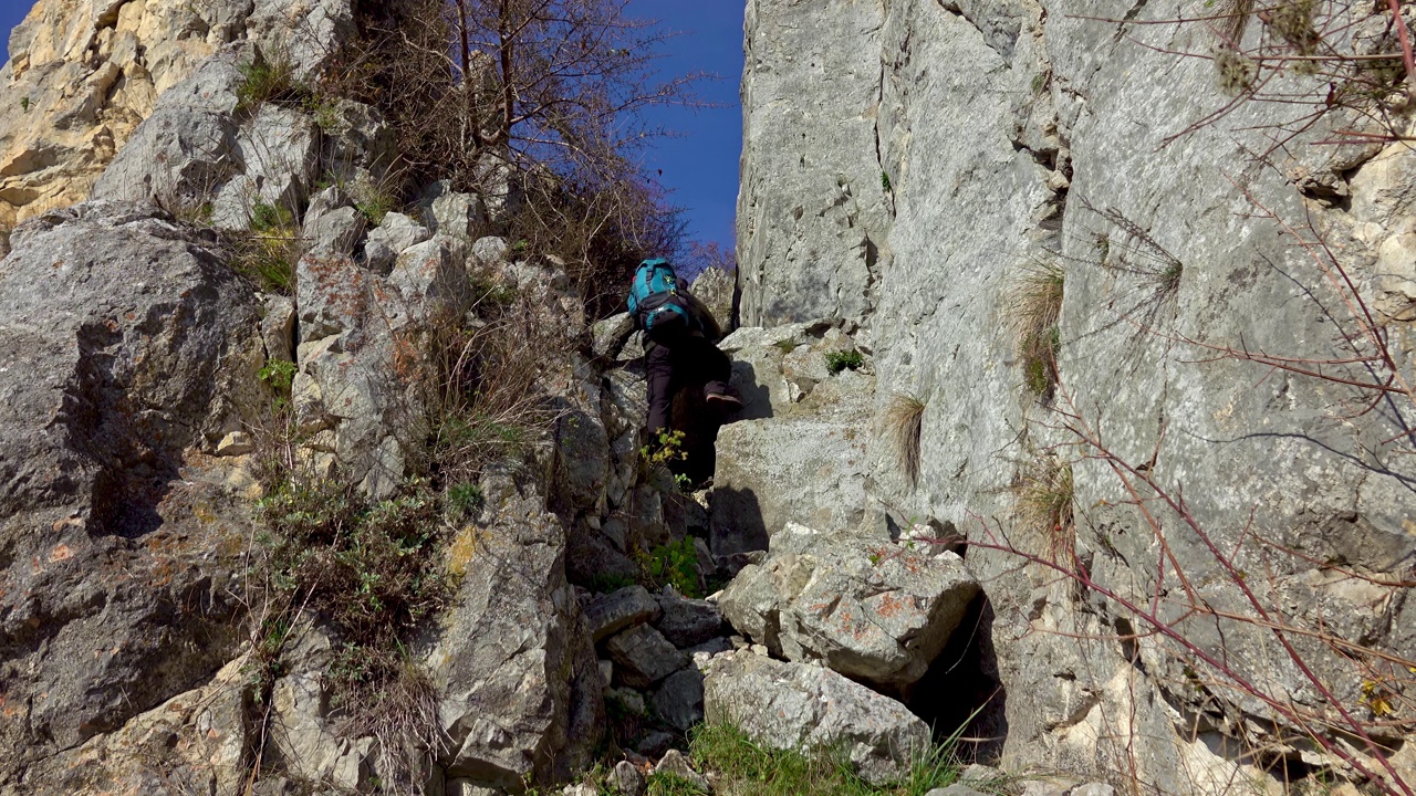 徒步旅行者沿着陡峭的碎石地形到达山顶视频素材