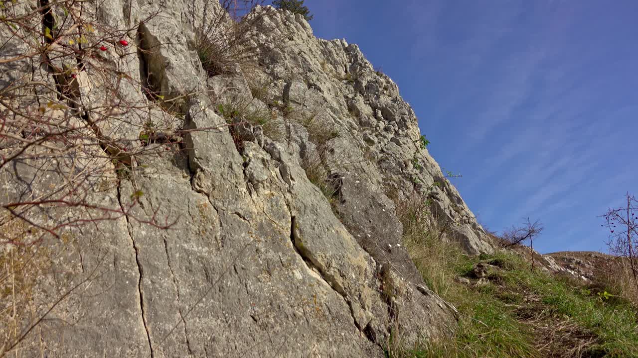 徒步旅行者沿着陡峭的碎石地形到达山顶视频素材