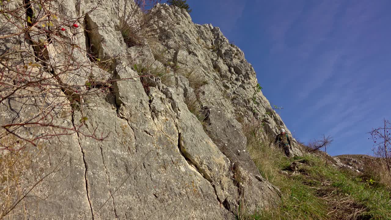 徒步旅行者沿着陡峭的碎石地形到达山顶视频素材