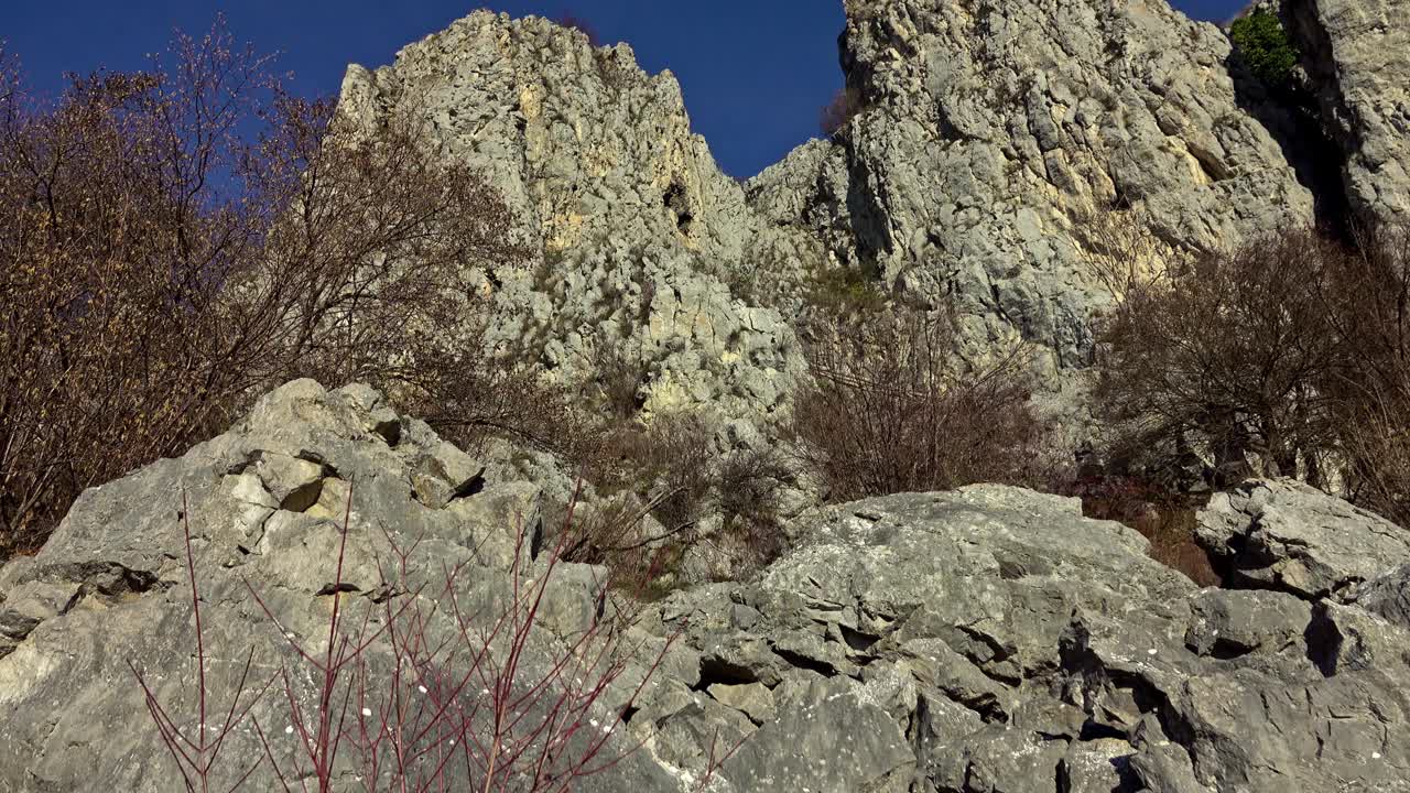 徒步旅行者沿着陡峭的碎石地形到达山顶视频素材