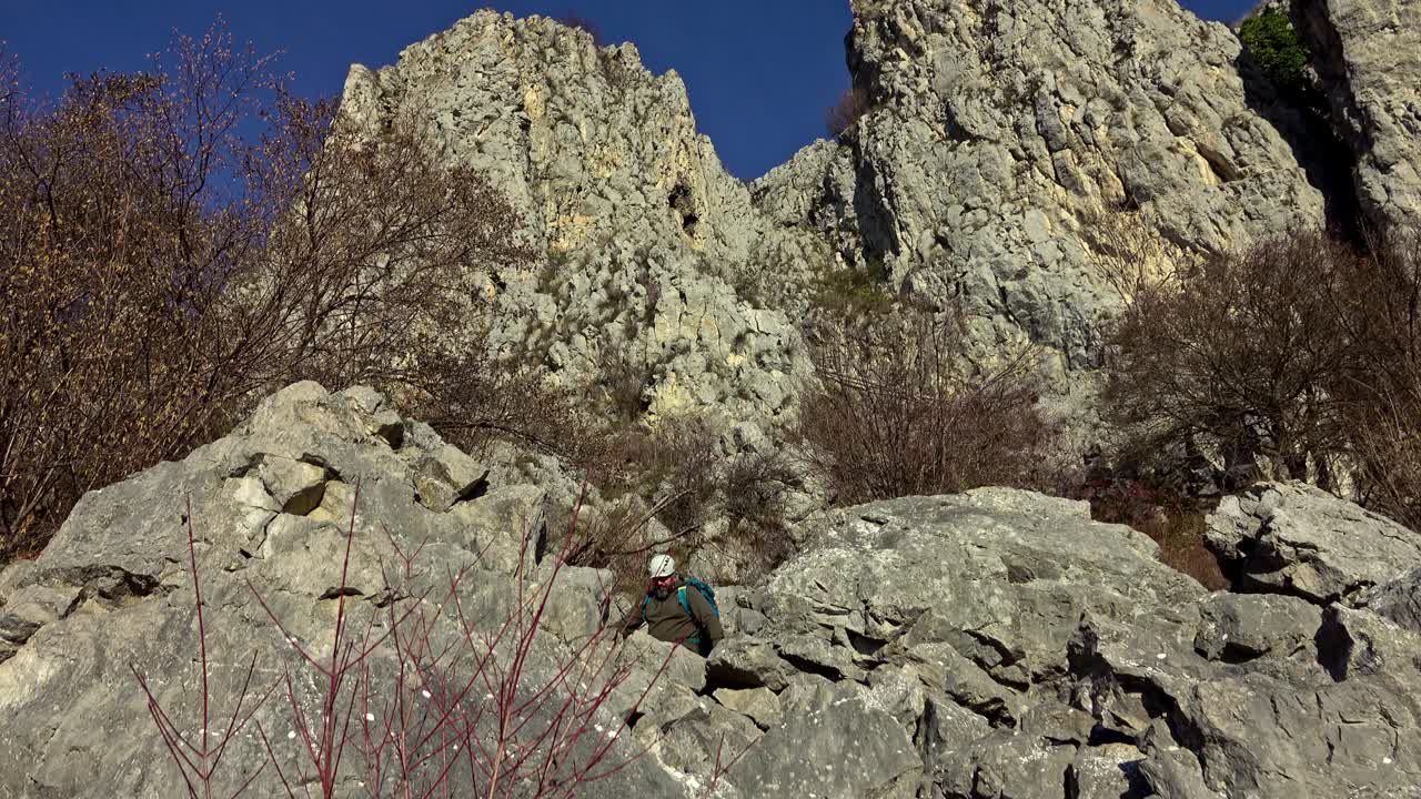 徒步旅行者沿着陡峭的碎石地形到达山顶视频素材