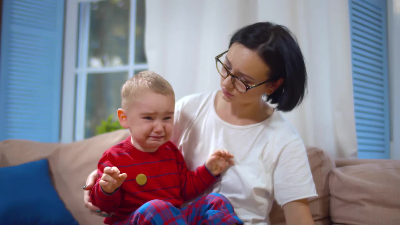 焦虑的母亲安慰哭泣的男婴。实时视频素材