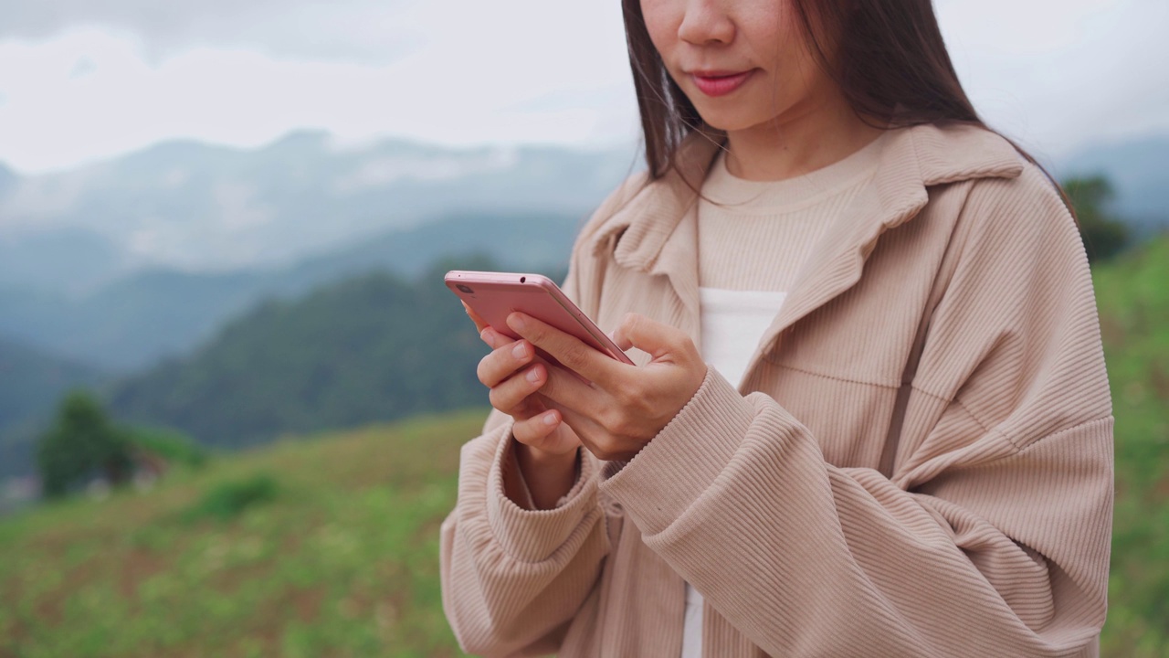 年轻女子旅行者放松和使用手机，而旅行度假视频素材