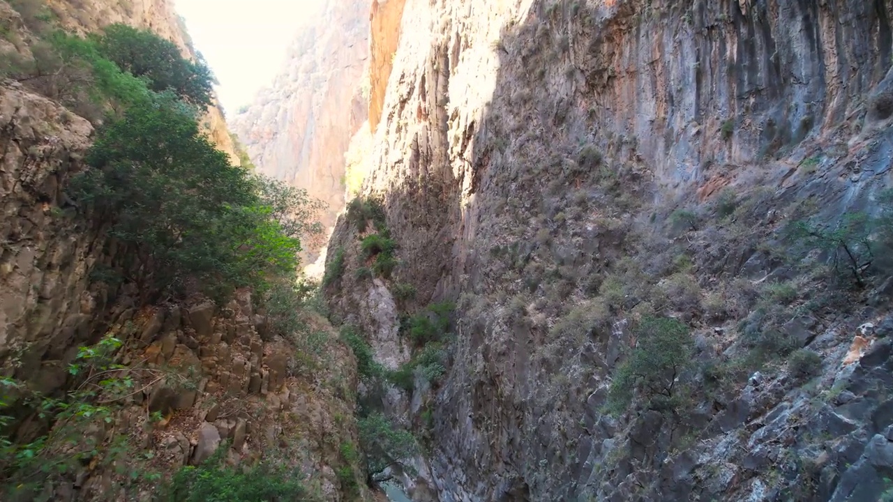 无人机在岩石间飞行极限峡谷空中飞行鸟瞰峡谷视频下载