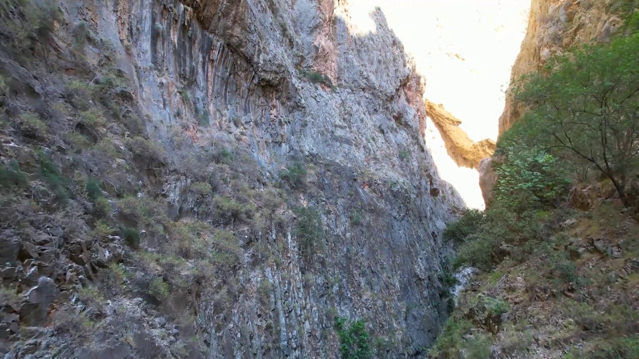 峡谷中的极限空中飞行无人机在岩石间飞行鸟瞰峡谷视频下载