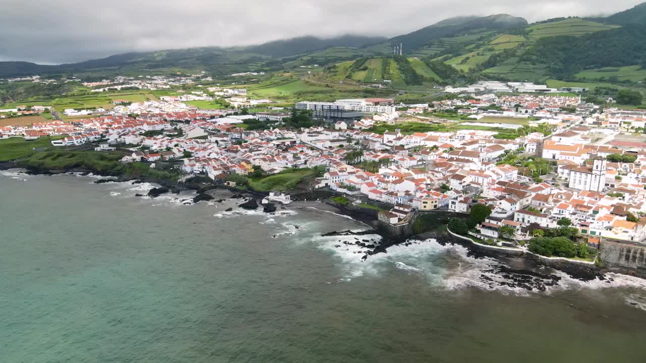 无人机拍摄揭示了火山海岸线与黑色岩石海滩和如画的村庄景色视频素材