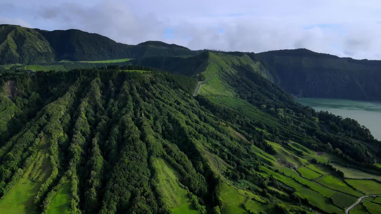 无人机拍摄的视频显示，绿色的火山山丘上有森林和湖泊视频素材