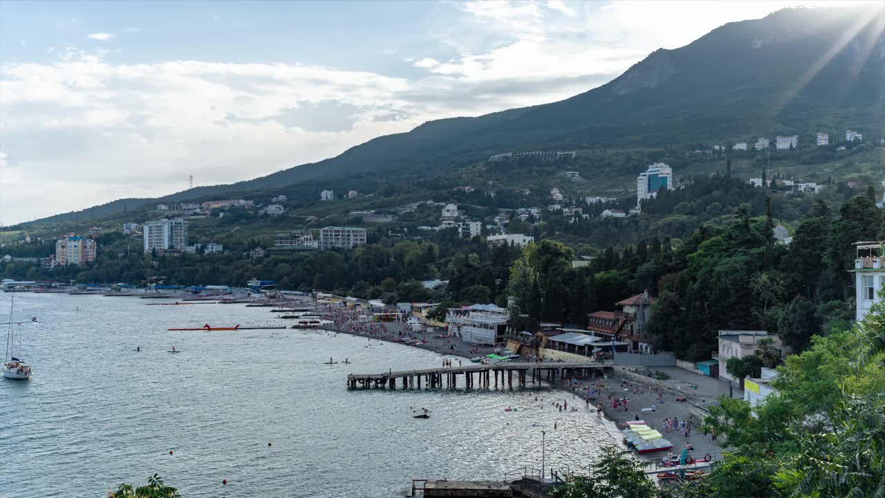 时间流逝的公共海滩与度假者，游客，咖啡馆，餐馆，酒店在山上。俯视图视频下载