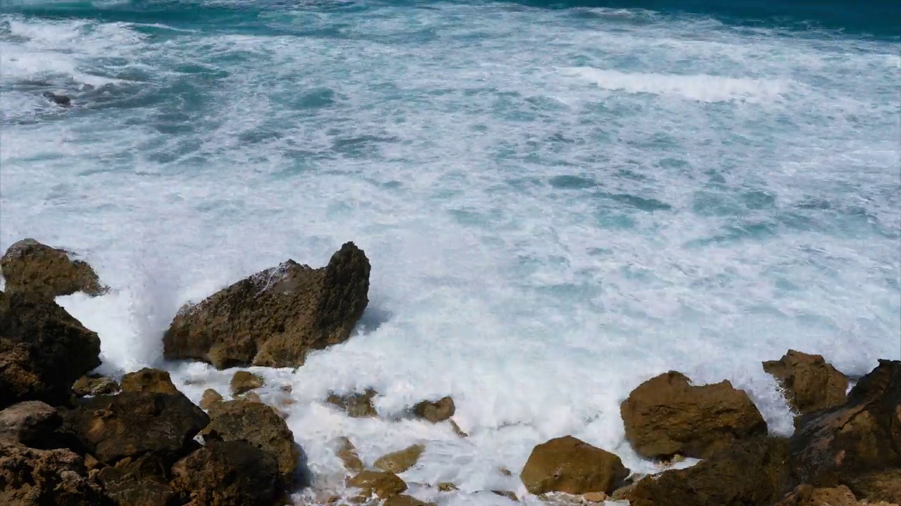 时间流逝，巨大的海浪在巨大的石头上破碎。俯视图视频下载