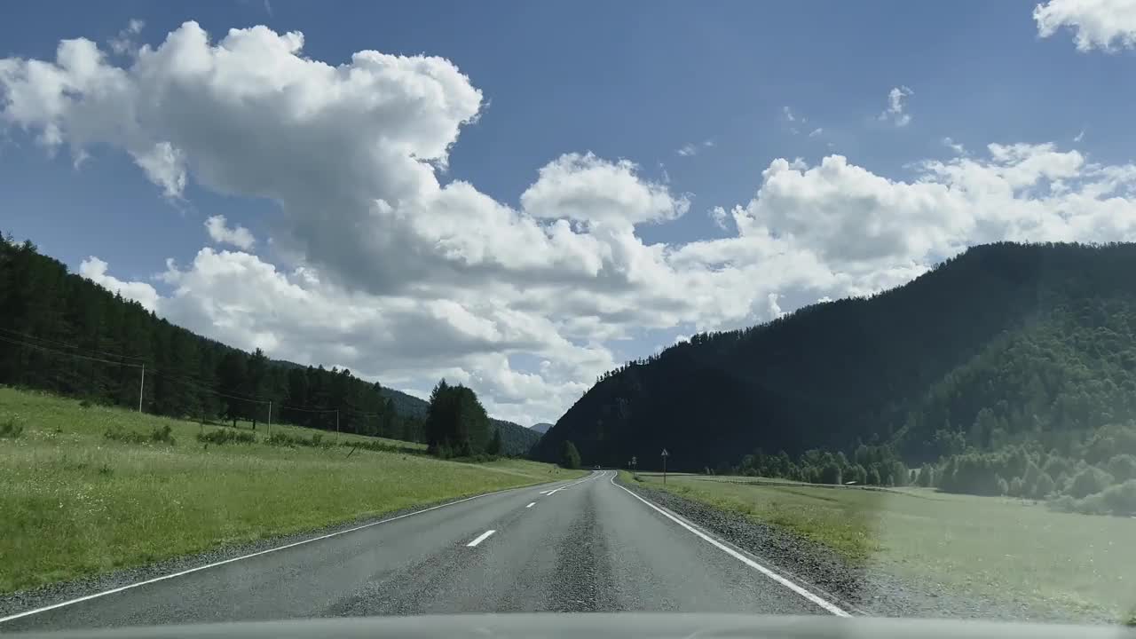 汽车在风景的背景下沿着山路行驶。视频素材