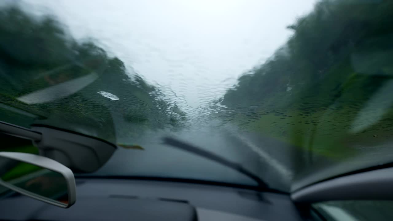 在恶劣天气开车。在雨天驾驶的汽车挡风玻璃特写视频素材