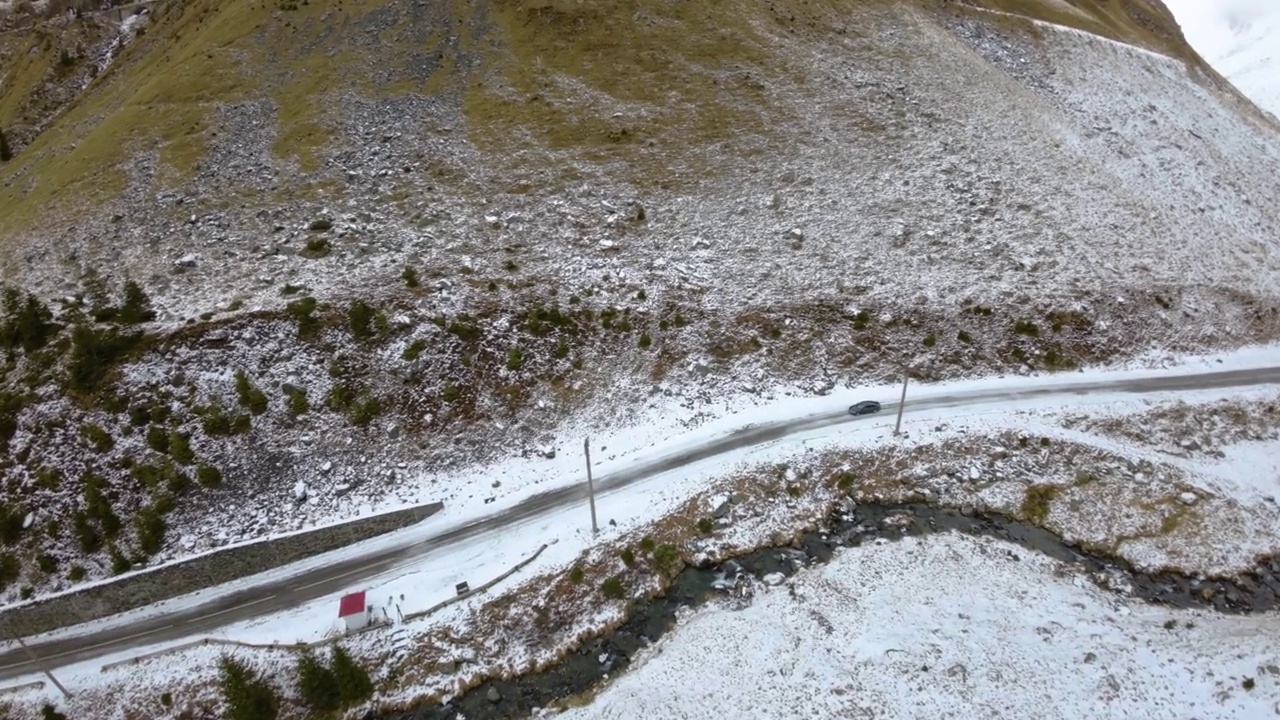 FPV鸟瞰汽车行驶在冰雪覆盖的冰冻山路上。高海拔公路。山上的高速公路。冬天结冰的山路。蜿蜒的道路关闭。山为视频素材