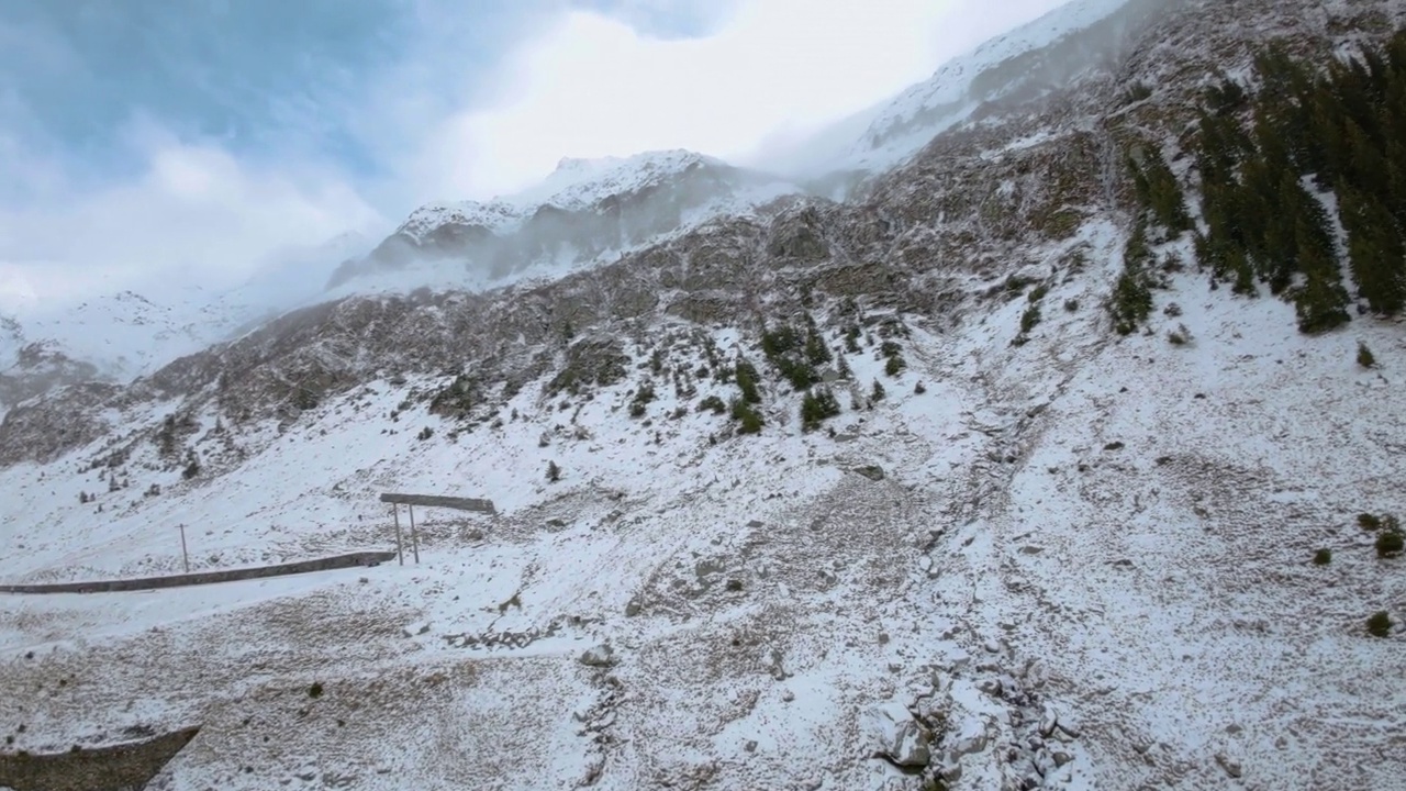 FPV鸟瞰汽车行驶在冰雪覆盖的冰冻山路上。高海拔公路。山上的高速公路。冬天结冰的山路。蜿蜒的道路关闭。山为视频素材