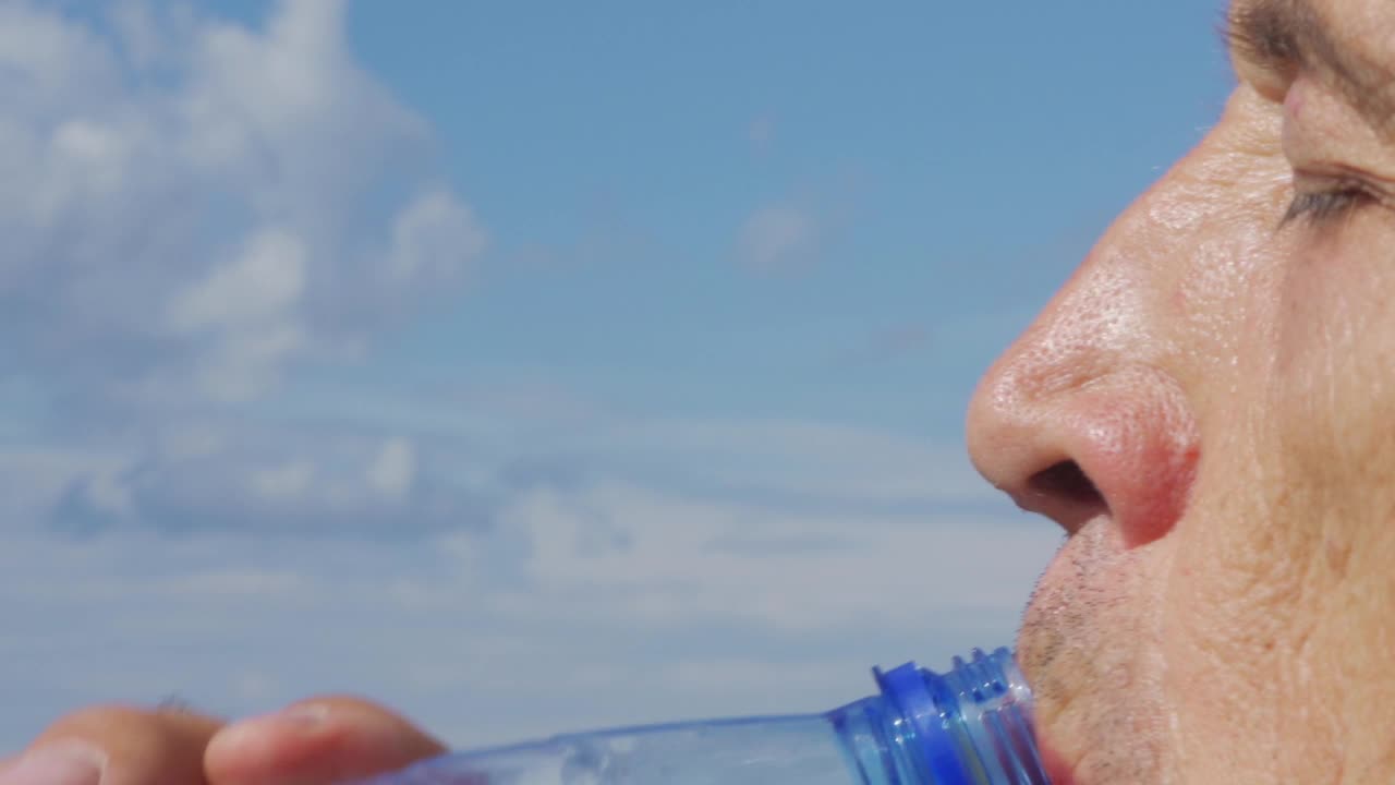 缓慢的运动。一个男人喝水特写。视频素材