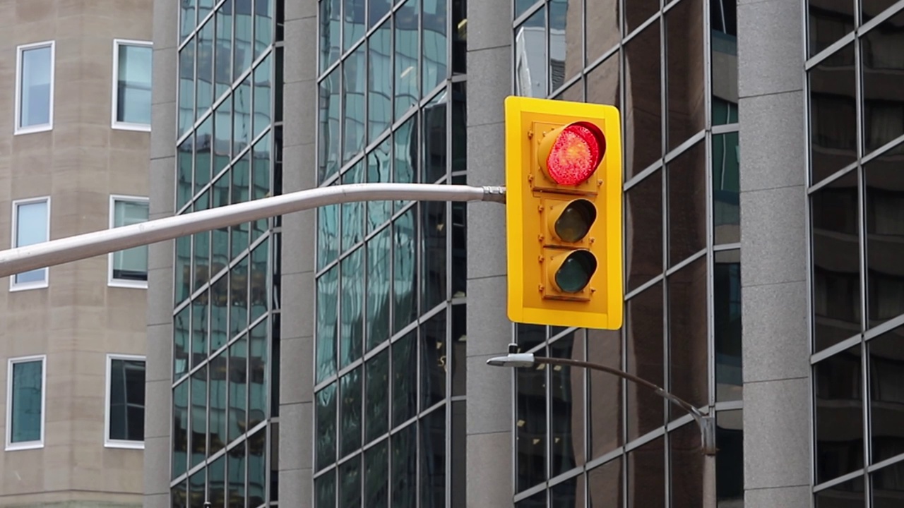 在加拿大渥太华市区的建筑物街道上，交通灯从红色变成绿色视频下载