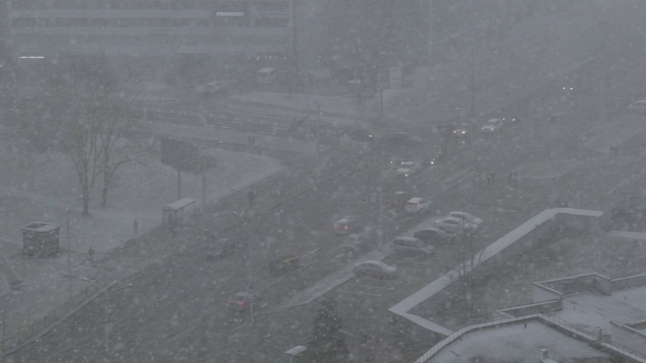 城市大雪，俯视图。十字路口的道路，汽车沿街道行驶。视频素材