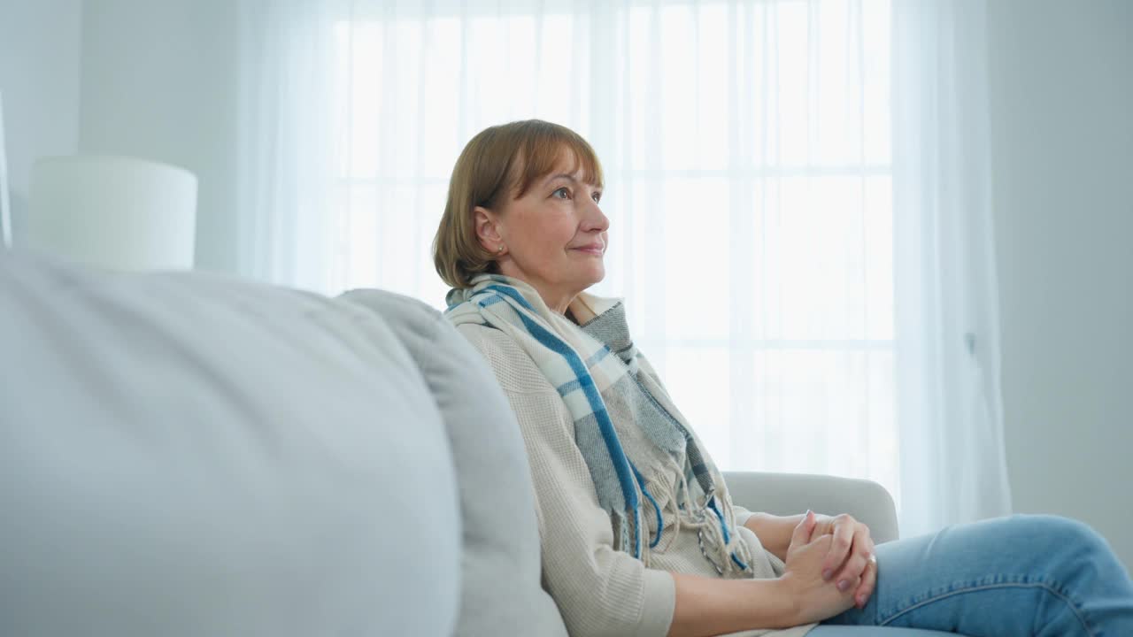 白种老年男子用生日礼物给妻子一个惊喜。有魅力的老男人坐在家里客厅的沙发上，把礼物盒送给成熟的祖母。祝贺的概念。视频素材