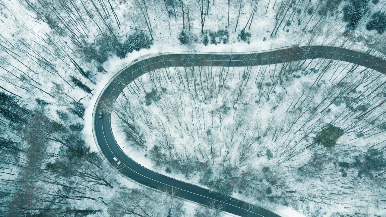 鸟瞰图的交通在蛇形的积雪覆盖的山路视频素材